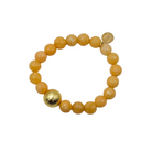 A beaded stretch bracelet featuring round, textured orange-yellow beads and one prominent metallic gold accent bead, displayed on a clean white background.