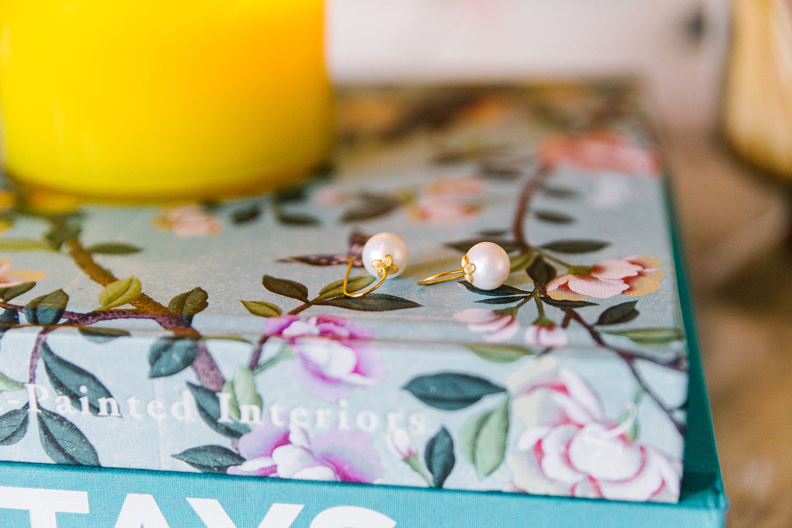 Bloom Pearl Hook earrings displayed on floral print book_m donohue collection